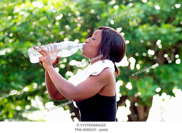 This young woman drinks mineral water after sport