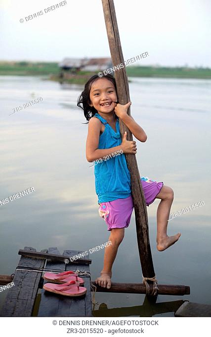 A young girl plays by the river in a small village outside of Phnom Penh, Cambodia