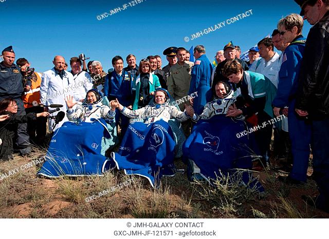 Three Expedition 23 crew members have just been seated in chairs near their Soyuz TMA-17 spacecraft just minutes after they landed near the town of Zhezkazgan