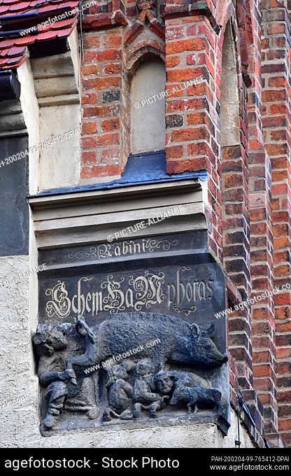 04 February 2020, Saxony-Anhalt, Wittenberg: A medieval sculpture called ""Judensau"" (Jewish sow) is on display on the outer wall of the town church of St