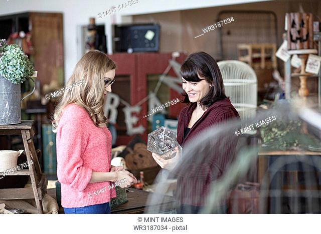 Two Caucasian women shopping in an antique store