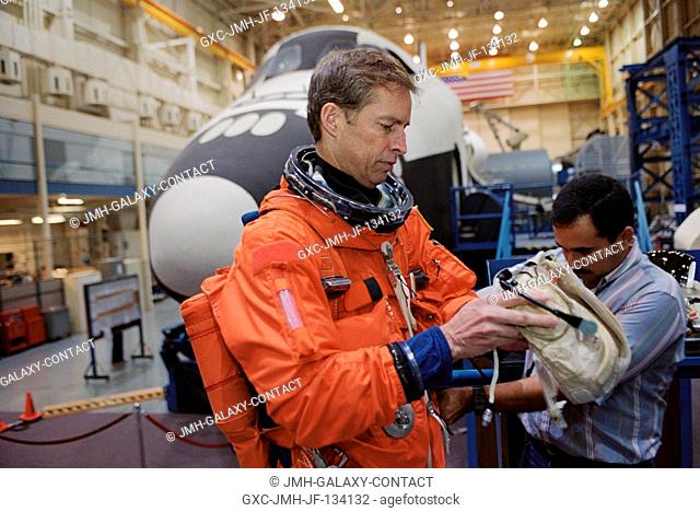Astronaut James D. Wetherbee, STS-113 mission commander, dons a training version of the full-pressure launch and entry suit prior to the start of a training...