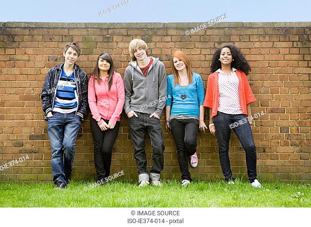 Teens standing by wall