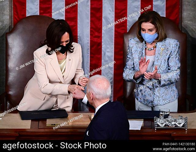 US President Joe Biden fist bumps US Vice President Kamala Harris as Speaker of the United States House of Representatives Nancy Pelosi (D-CA) looks on after he...