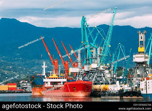Batumi, Adjara, Georgia. Old Barge Freight Ship Tanker And Heavy Loading Cranes Jib In Port Dock