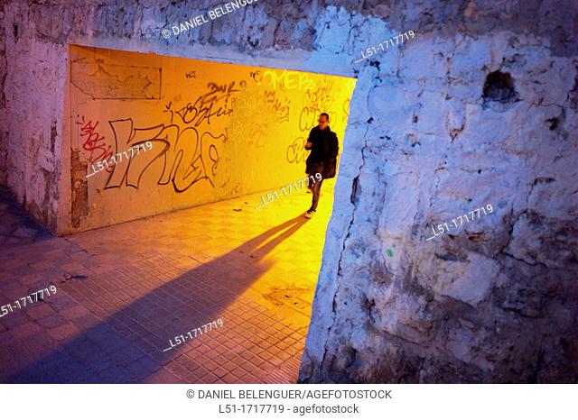 Young man walking through a tunnel at dusk, Valencia city, valencia, Spain