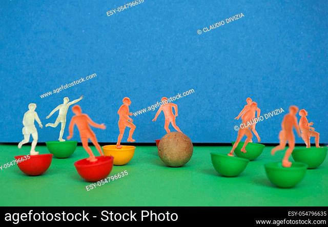 plastic toy soccer players playing football sport with wooden ball