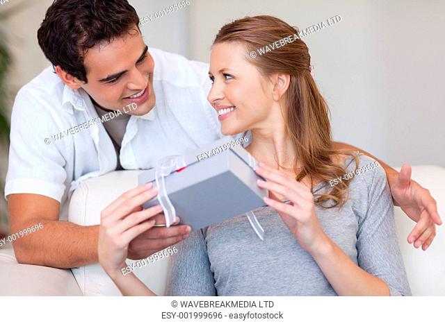 Young woman smiling happily about the present she just got from her boyfriend