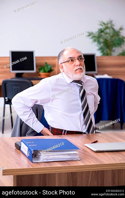 Old employee suffering from radiculitis at workplace