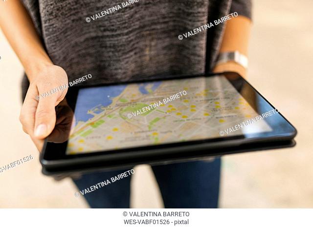 Close-up of woman holding tablet with digital street map