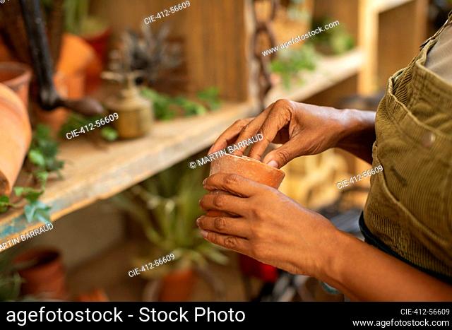 Close up woman with small flowerpot in plant nursery