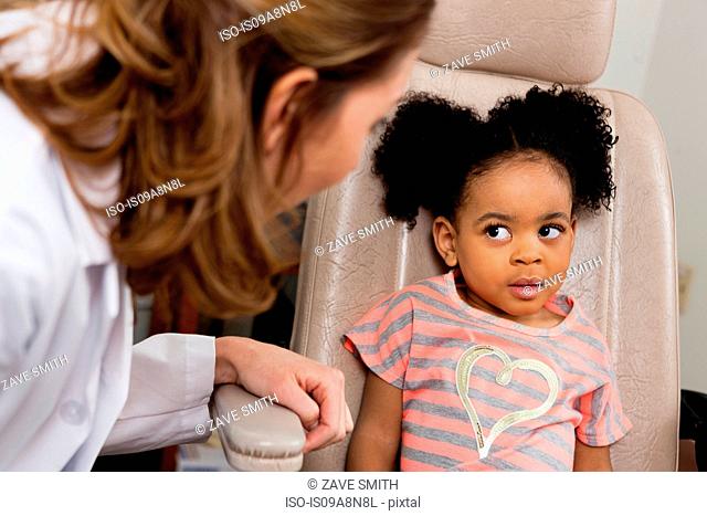 Mid adult doctor talking to young patient