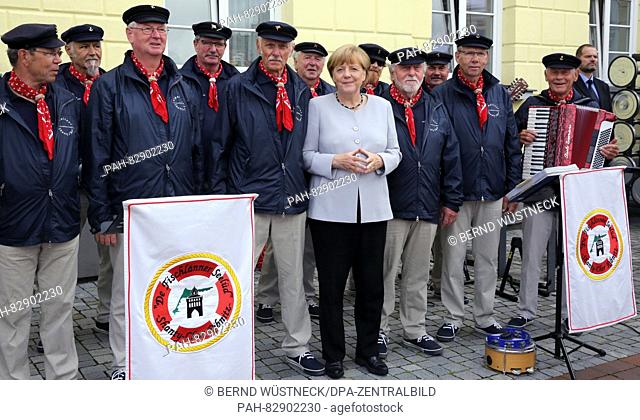 German Chancellor Angela Merkel (CDU) poses for a photograph with the shanty choir De Fischlarnner Seelued during an election campaign appearance in...