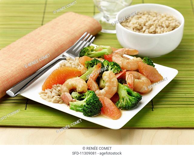 Healthy brown rice with oranges, broccoli and prawns