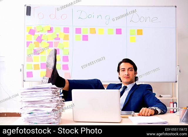Young handsome employee in front of whiteboard with to-do list