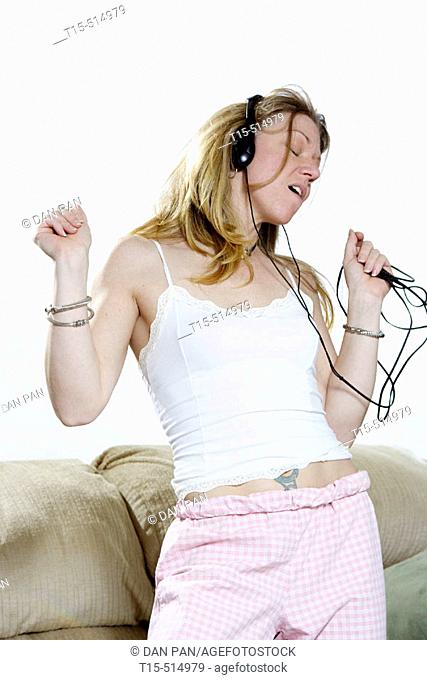 Woman in living room dancing listening to music
