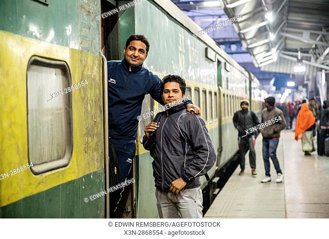 Two men stand in the entrance of a train car at the Ludhiana Junction railway station in Ludhiana, India