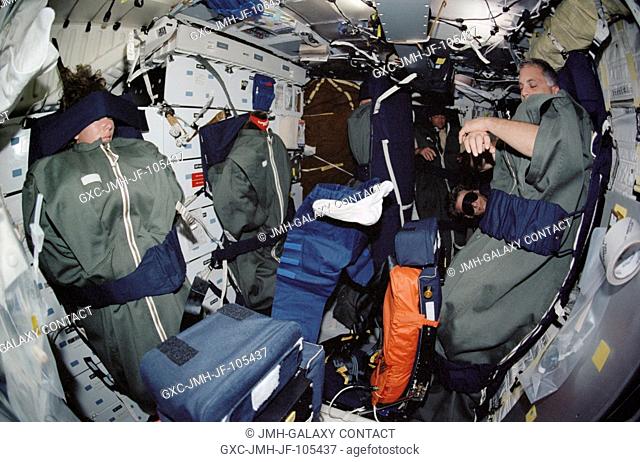 The STS-112 crewmembers sleep on the middeck of the Space Shuttle Atlantis. Pictured are astronauts Sandra H. Magnus, David A. Wolf, Piers J