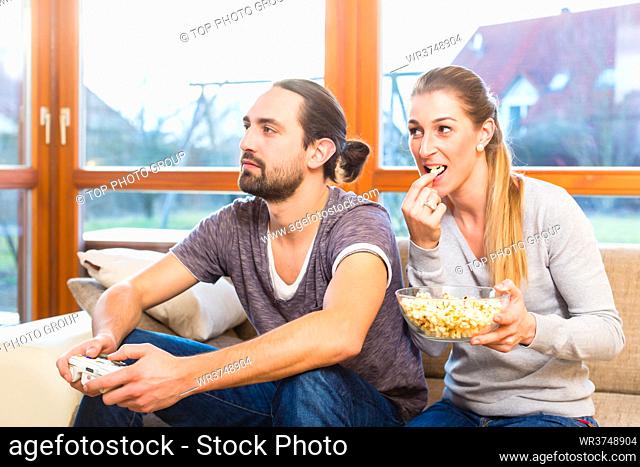 Couple having leisure time together and playing with video game console