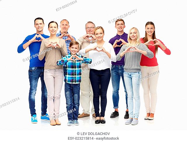 gesture, family, generation and people concept - group of smiling men, women and boy showing heart shape hand sign