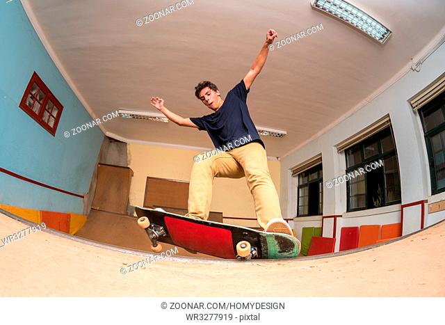 Skateboarder performing a trick on mini ramp at indoor skate park