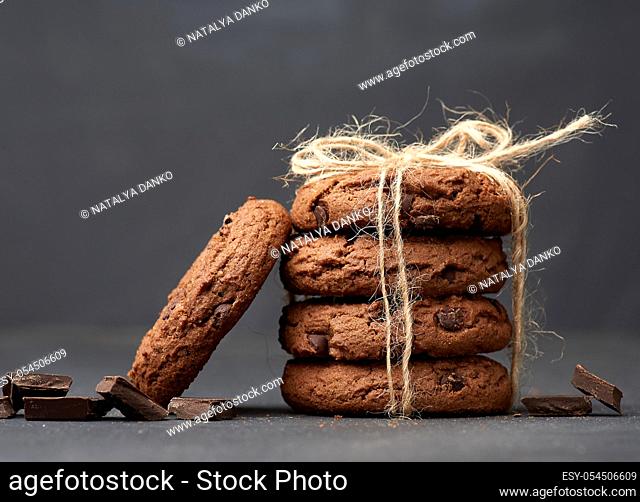 stack of round chocolate chip cookies tied with a rope on a black board, delicious dessert