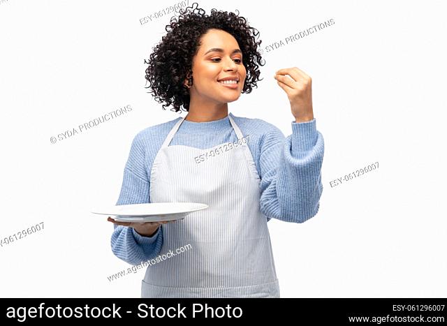smiling woman in apron holding empty plate