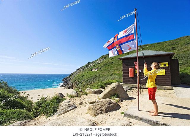 Woman flying a flag, Porthcurno Beach, Penwith peninsula, Cornwall, England, United Kingdom