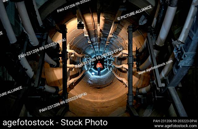06 December 2023, Berlin: A worker is seen in a section of the Berlin tunnel of the cable diagonal on the site of the Berlin-Friedrichshain substation during...