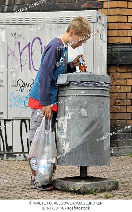 Nine year old boy earning his pocket money by collecting returnable bottles, Germany, Europe