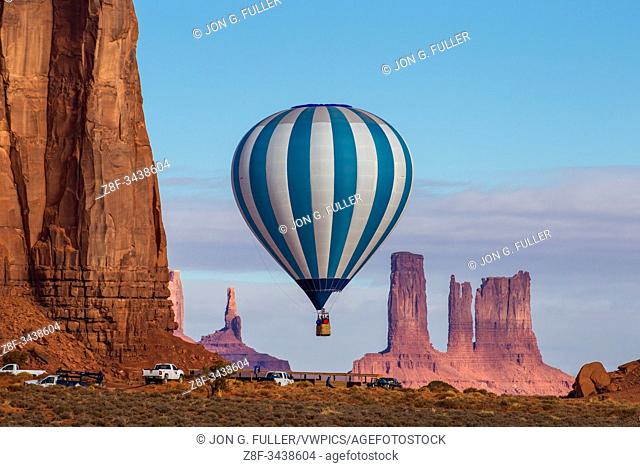 A hot air balloon flying in front of the Utah Monuments in the Monument Valley Balloon Festival in the Monument Valley Navajo Tribal Park in Arizona