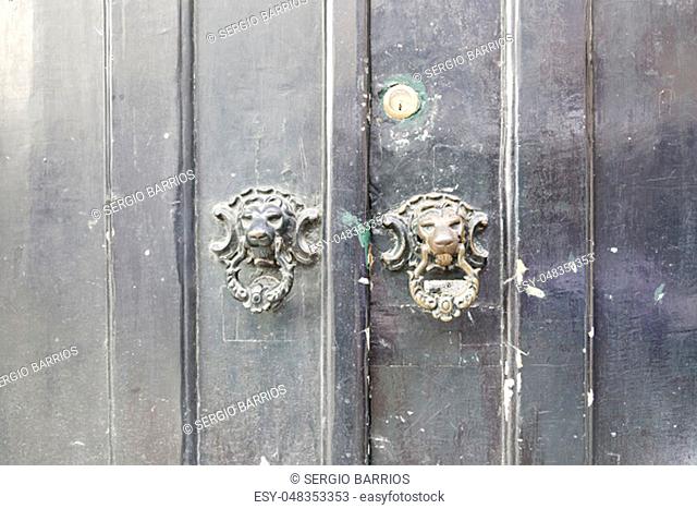 Wooden door with metal knockers, door detail of a decorated, safety and security