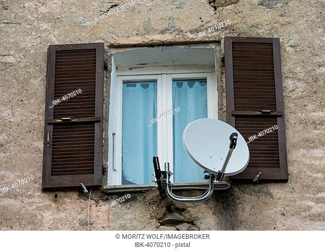 Window in a dilapidated building with satellite dish and open shutters, Corte, Corsica, France