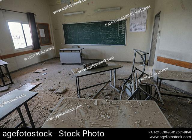 30 May 2021, Palestinian Territories, Gaza City: A general view of an exploded Israeli shell inside a damaged classroom of a school that was hit during the...