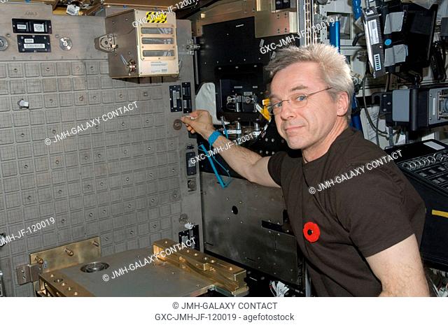 Canadian Space Agency astronaut Robert Thirsk, Expedition 21 flight engineer, installs the Light Microscopy Module (LMM) Spindle Bracket Assembly in the Fluids...