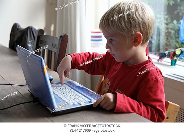 Little boy playing computer game, Netherlands