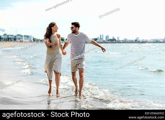 happy couple running along summer beach