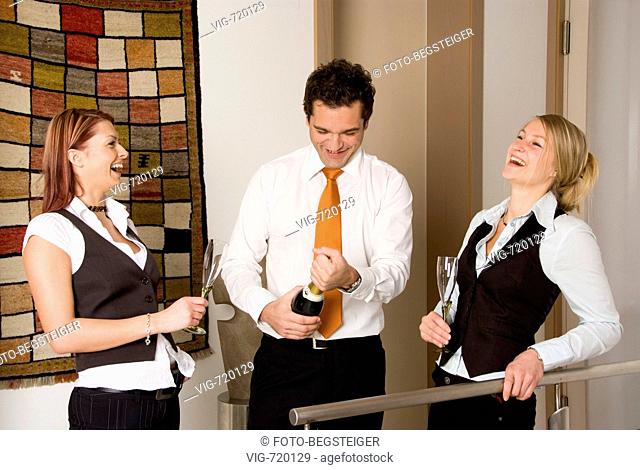 three young business people drinking sparkling wine. - 07/04/2008