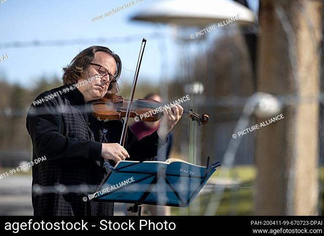 11 April 2020, Thuringia, Weimar: Gernot Süßmuth, concertmaster of the Staatskapelle Weimar, plays the violin in front of the Buchenwald Memorial for the...