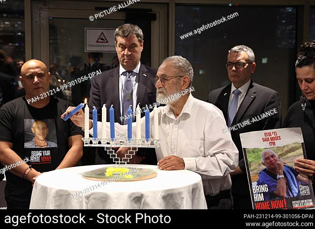 14 December 2023, Israel, Tel Aviv: Relatives of the hostages kidnapped by Hamas light Hanukkah candles in front of Markus Söder (CSU, M)