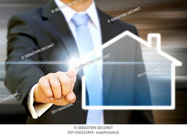 Businessman drawing a house with his finger on a tactile screen