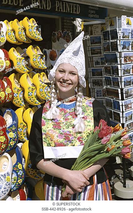 Girl Dressed in Dutch Costume Holding Tulips, Souvenir Store Selling Clogs and Postcards, Amsterdam, Netherlands