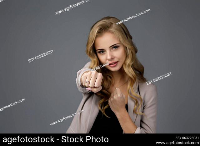 Portrait of young woman with fists raised ready to fight