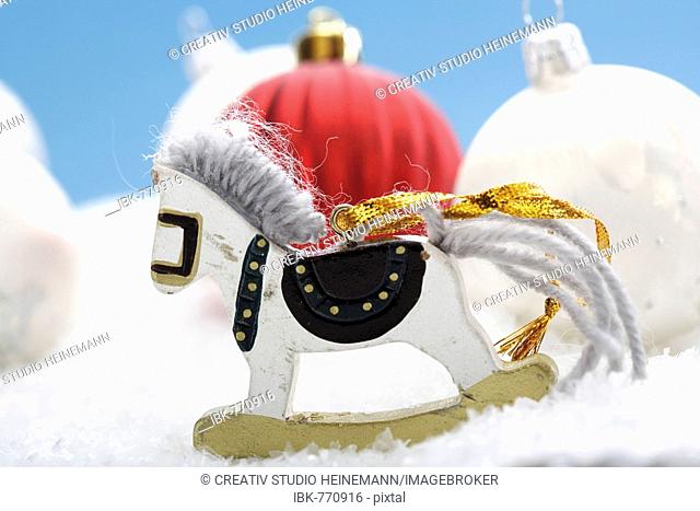 Little rocking horse on artificial snow, Christmas ornaments