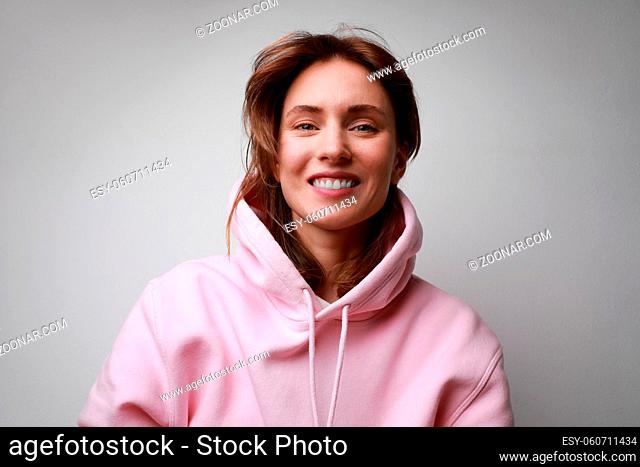 Young woman with shocked face expression, posing on white background wall. High quality photo