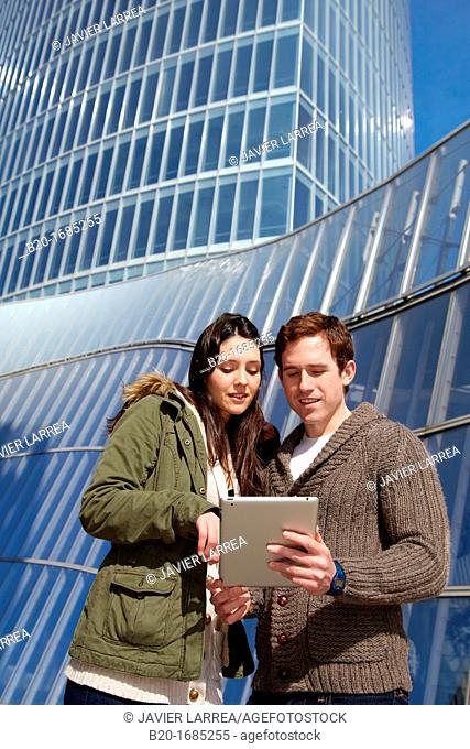 Couple searching on digital tablet in city, digital tablet, Iberdrola Tower, Abandoibarra, Bilbao, Bizkaia, Basque Country, Spain