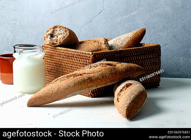 Small loaves of whole wheat bread with a glass of milk