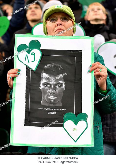 A Wolfsburg fan holds high a sign with a picture of Junior Malanda, who suffered a fatal accident, during the German Bundesliga soccer match VfL Wolfsburg vs FC...
