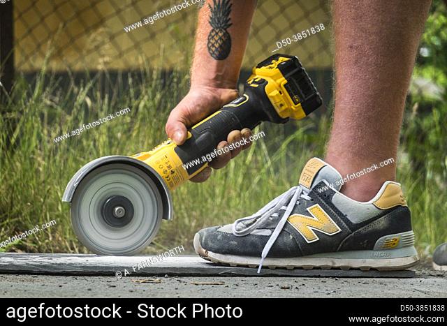 Stockholm, Sweden A man uses a rotary saw power tool to cut a stone slab
