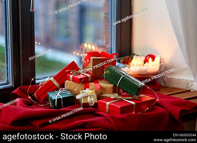 christmas gifts on red tablecloth on window sill